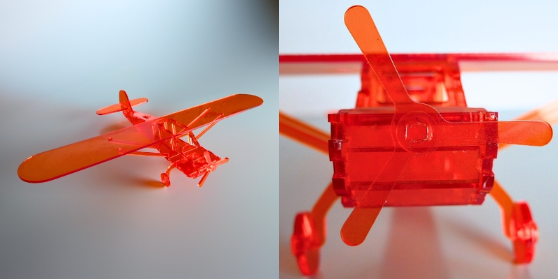 Miniature prototype of an aircraft, made from transparent orange acrylic, made with the Atheon CO2 Laser